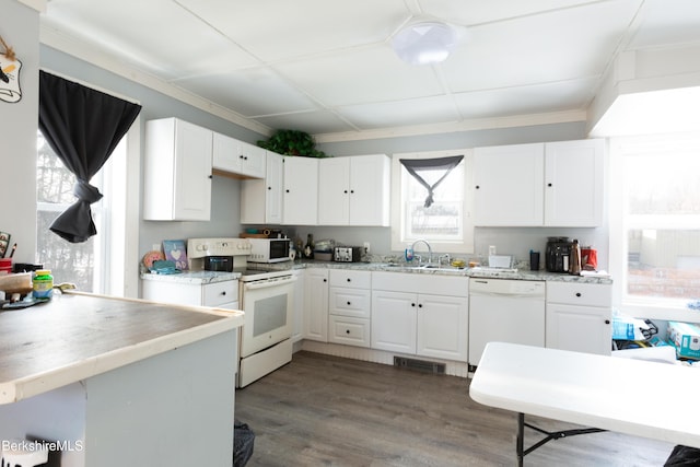 kitchen with white cabinetry, a sink, white appliances, and visible vents