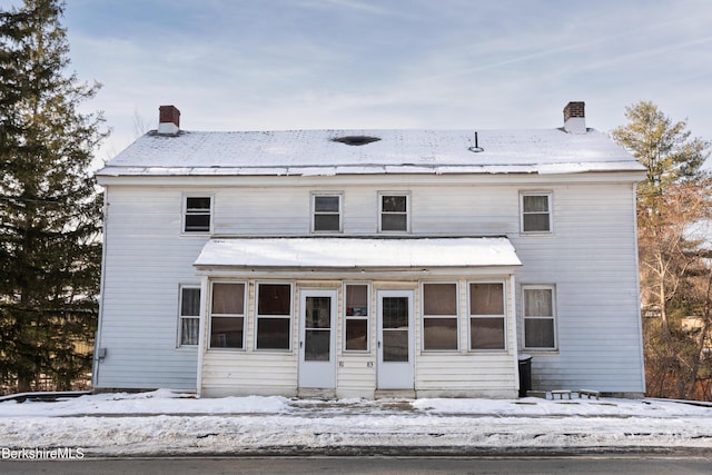 view of front of property with a sunroom and a chimney