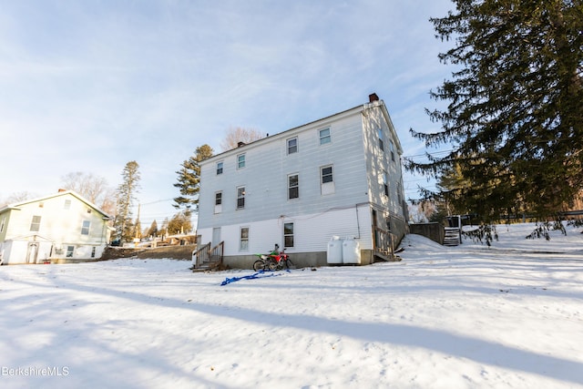 snow covered property with a chimney