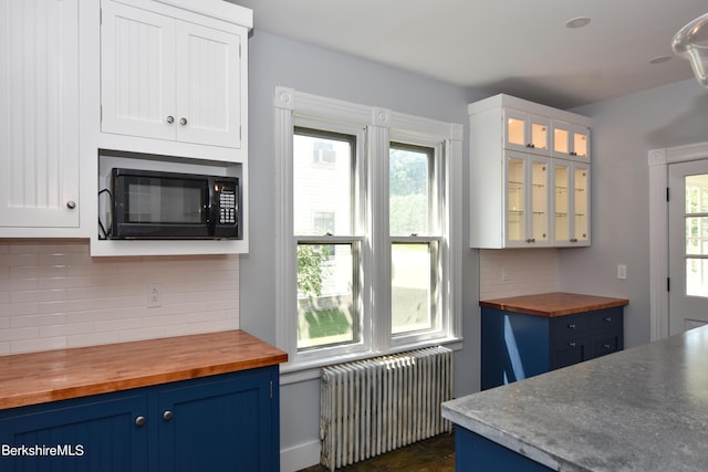 kitchen featuring white cabinets, radiator heating unit, tasteful backsplash, and wood counters