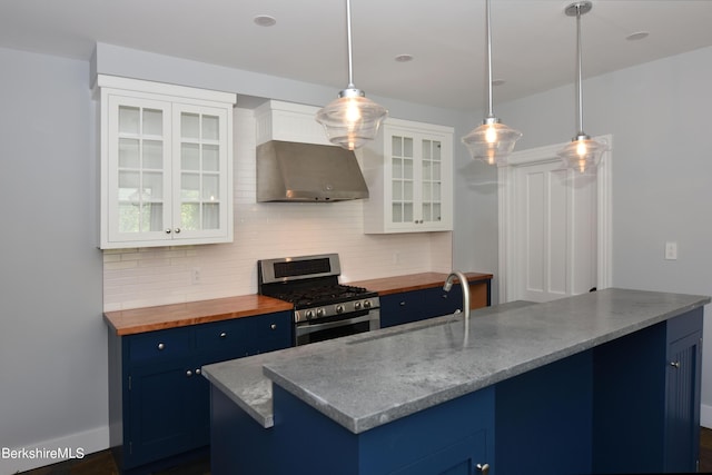 kitchen with stainless steel gas range, hanging light fixtures, wall chimney exhaust hood, white cabinetry, and blue cabinets