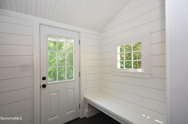 mudroom featuring wooden walls and lofted ceiling