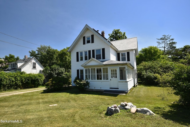 view of front of property with a front yard and a sunroom