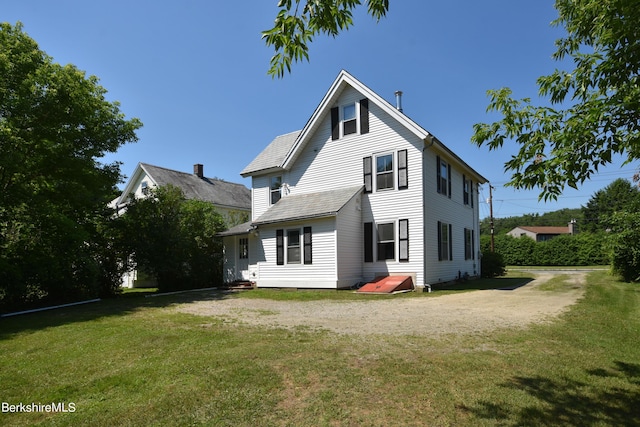 rear view of property with a lawn