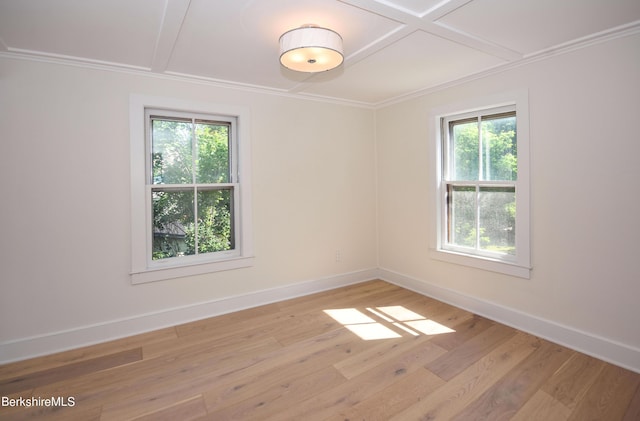 unfurnished room featuring light hardwood / wood-style floors, coffered ceiling, ornamental molding, and a wealth of natural light