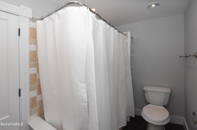 bathroom featuring toilet and a shower with curtain