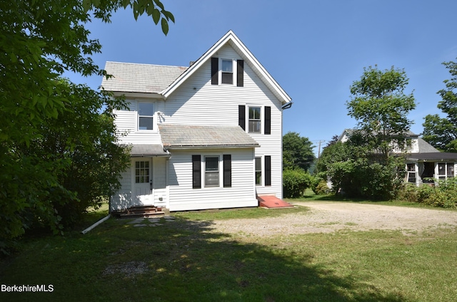 rear view of property with a yard