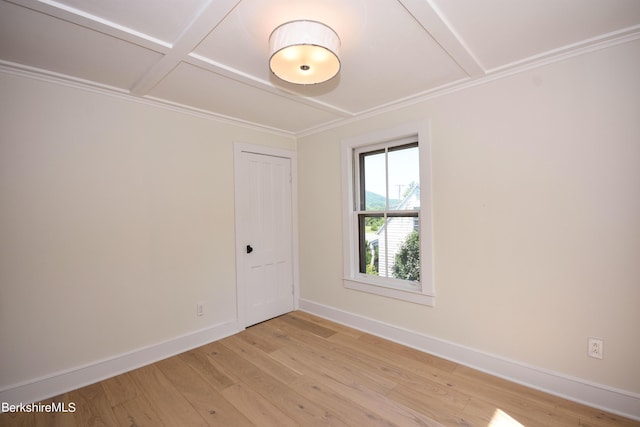 spare room featuring light wood-type flooring and coffered ceiling