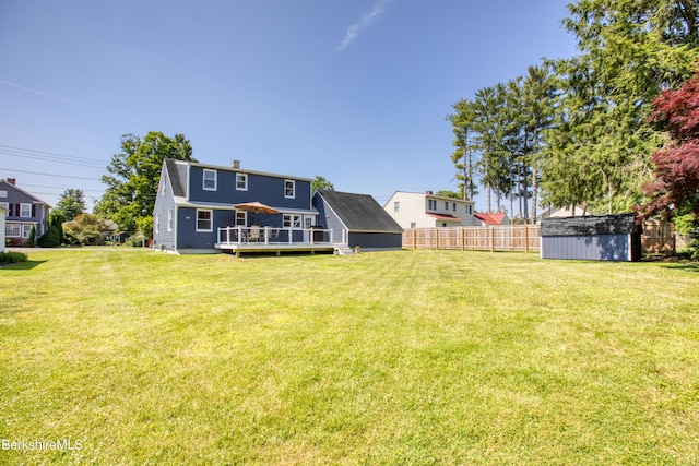 view of yard featuring a wooden deck and a storage shed