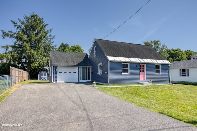 view of front of property with a garage, a front yard, and a storage unit