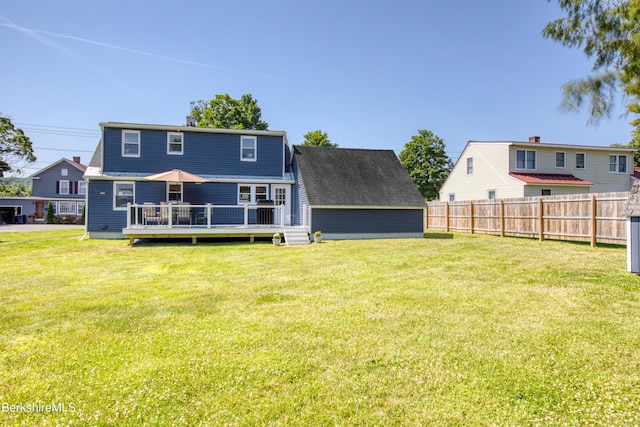 back of house with a deck and a yard