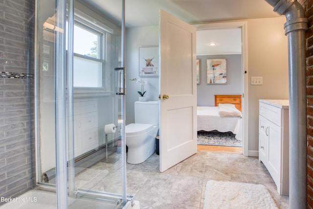 bathroom featuring vanity, toilet, and a shower with shower door