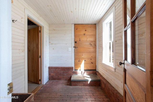 649 Hewins St, Sheffield, MA 01257 - corridor featuring brick floors, wooden ceiling, wooden walls, and plenty of natural light