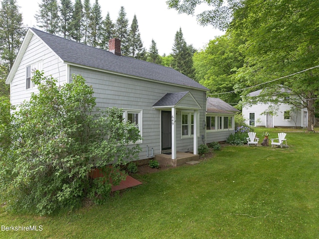 649 Hewins St, Sheffield, MA 01257 - view of front of property featuring a chimney, roof with shingles, and a front lawn