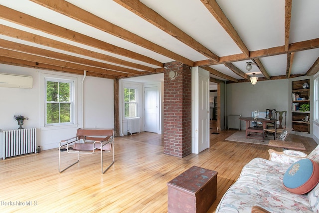 649 Hewins St, Sheffield, MA 01257 - living area featuring radiator heating unit, a wall unit AC, wood-type flooring, and beam ceiling