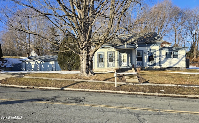 view of front of property featuring a garage and an outbuilding