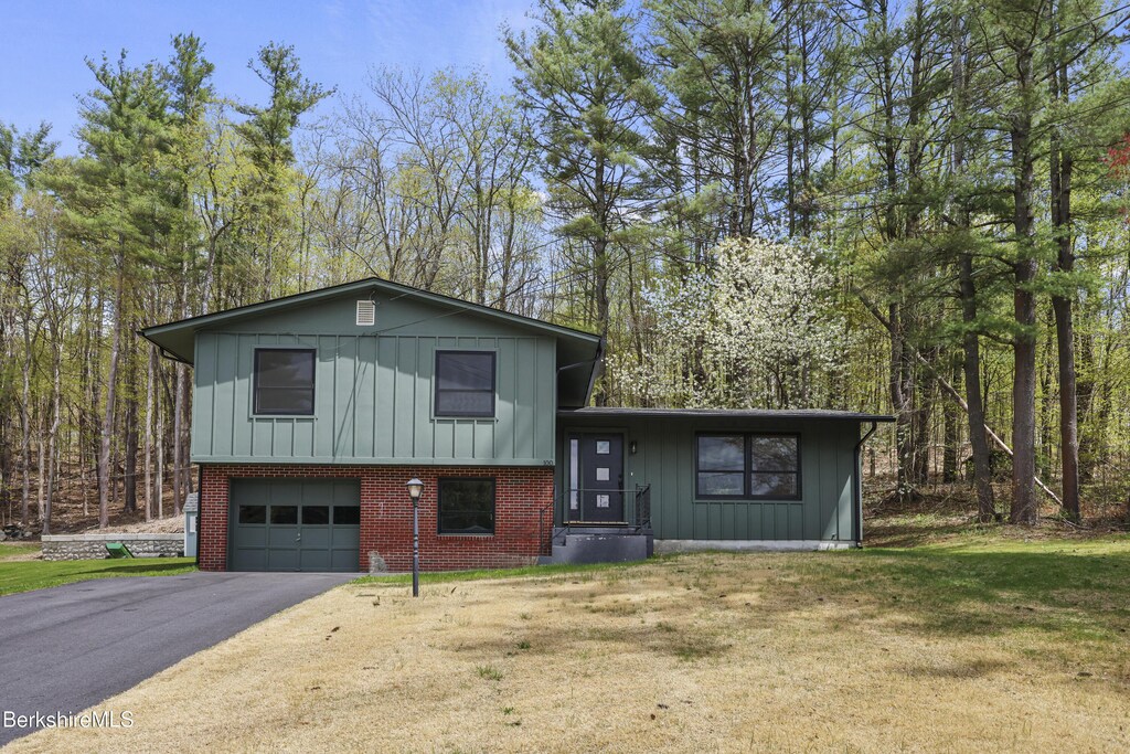 100 Autumn Dr, North Adams, MA 01247 - tri-level home with a garage, a front lawn, board and batten siding, and driveway
