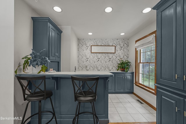 67 Dunmore Ct, Lenox, MA 01240 - kitchen with a breakfast bar, a peninsula, recessed lighting, light tile patterned floors, and an accent wall