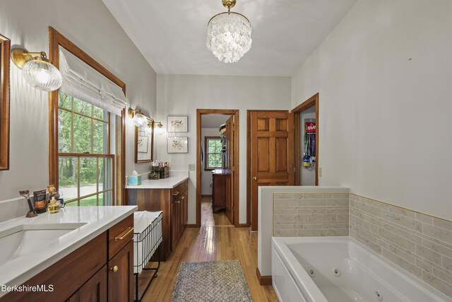 67 Dunmore Ct, Lenox, MA 01240 - full bath with two vanities, wood finished floors, a chandelier, and a jetted tub