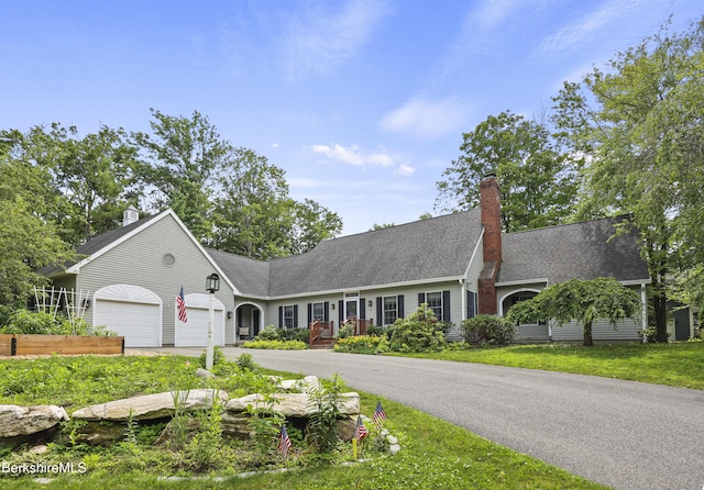 67 Dunmore Ct, Lenox, MA 01240 - view of front of house with driveway, a chimney, an attached garage, and a shingled roof