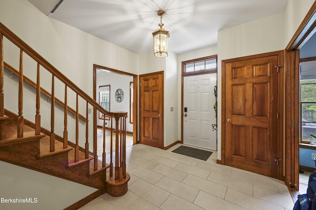67 Dunmore Ct, Lenox, MA 01240 - foyer with stairway, a chandelier, and light tile patterned flooring