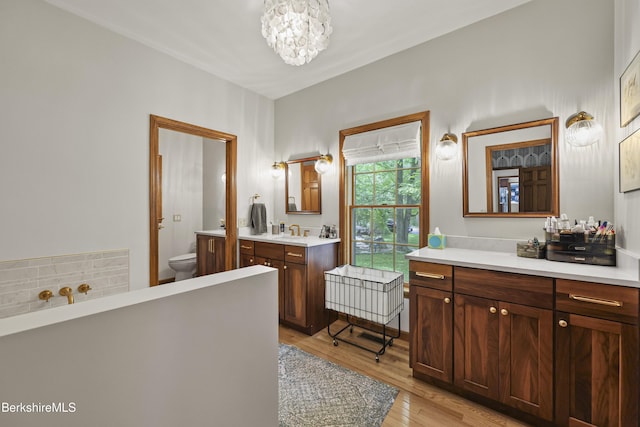 67 Dunmore Ct, Lenox, MA 01240 - full bath with wood finished floors, vanity, a chandelier, and a tub to relax in