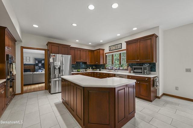 67 Dunmore Ct, Lenox, MA 01240 - kitchen with stainless steel appliances, light countertops, backsplash, a kitchen island, and recessed lighting