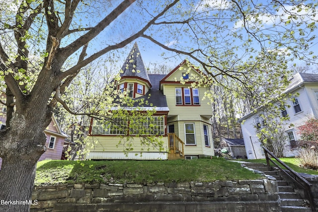rear view of house featuring a lawn
