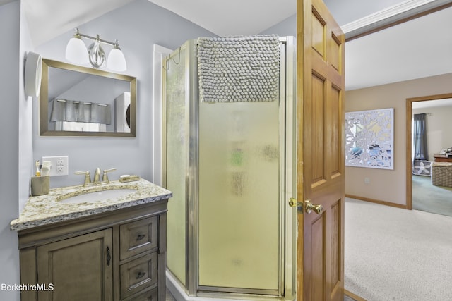 full bath featuring vanity, baseboards, a stall shower, and vaulted ceiling