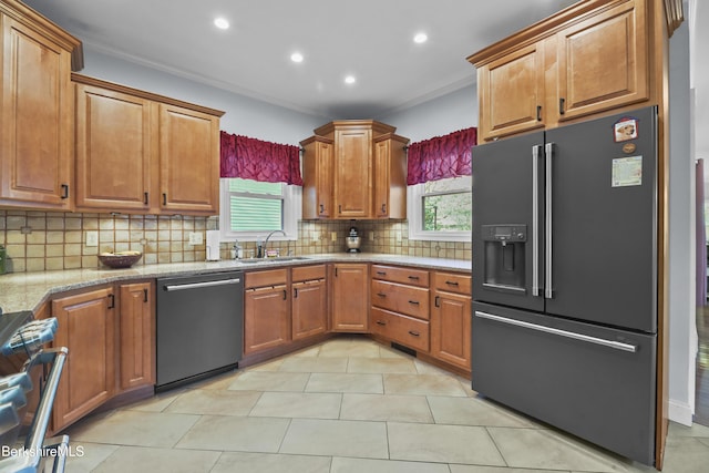 kitchen featuring high end black refrigerator, tasteful backsplash, dishwasher, a sink, and ornamental molding