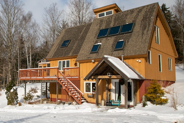 snow covered property featuring a wooden deck