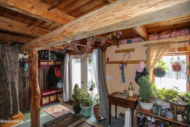 interior space featuring concrete flooring, beam ceiling, and french doors