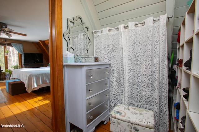 bathroom with ceiling fan and hardwood / wood-style floors