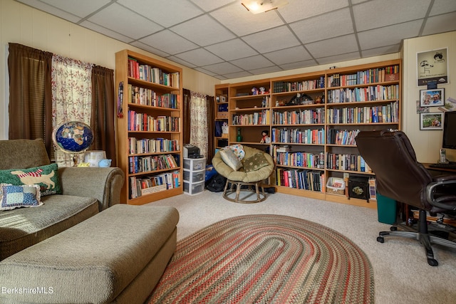 living area with carpet floors and a drop ceiling