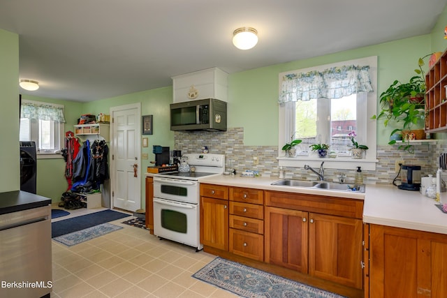 kitchen featuring stainless steel microwave, range with two ovens, a sink, and light countertops