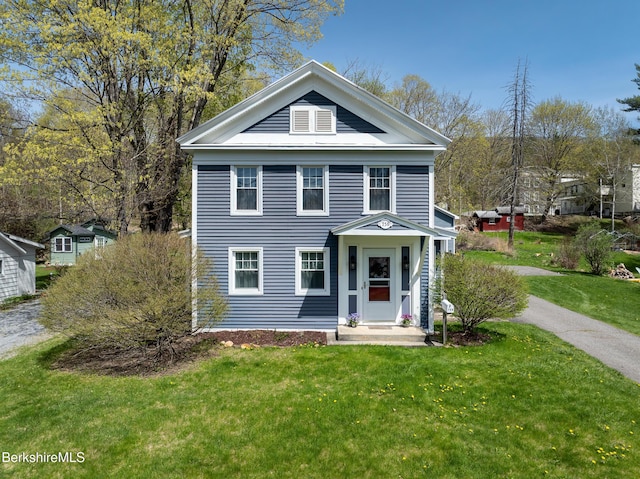 neoclassical / greek revival house featuring a front lawn