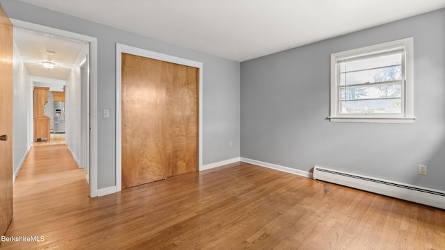 33 Quirico Dr, Pittsfield, MA 01201 - unfurnished bedroom with light wood-type flooring, baseboard heating, a closet, and stainless steel refrigerator with ice dispenser