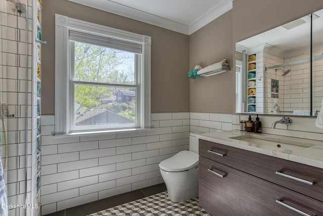 full bathroom with tile walls, a tile shower, toilet, vanity, and tile patterned floors