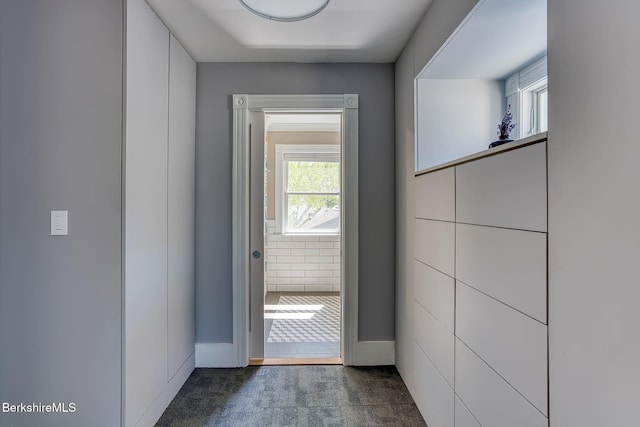 doorway to outside with carpet and baseboards