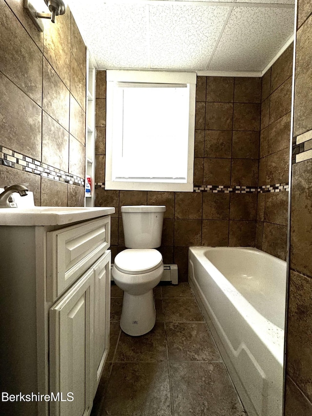 full bathroom with vanity, toilet, tile walls, and a baseboard heating unit