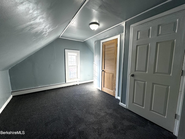 bonus room with vaulted ceiling, dark carpet, and a baseboard heating unit