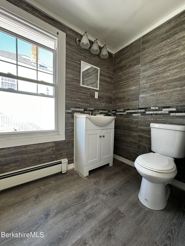 bathroom featuring vanity, hardwood / wood-style floors, a baseboard radiator, and toilet