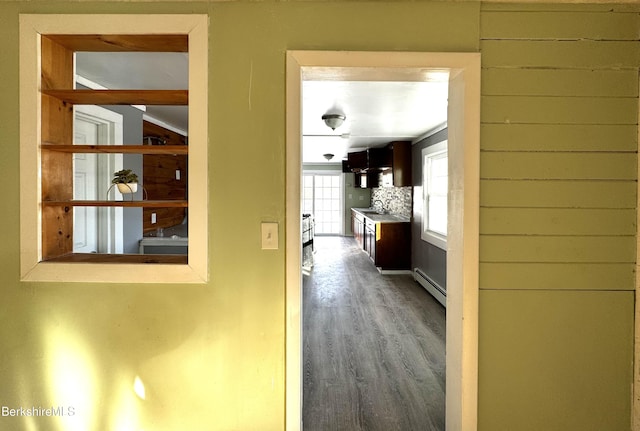 hall featuring hardwood / wood-style flooring, a baseboard radiator, and sink