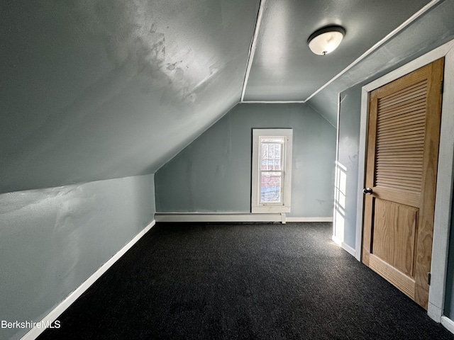 additional living space with vaulted ceiling, carpet flooring, and a baseboard radiator