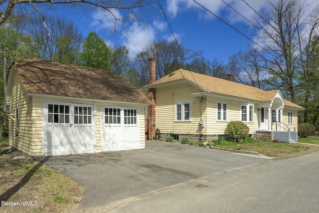 12 Riverfront St, Chester, MA 01011 - view of front of property with a chimney, an outbuilding, roof with shingles, and a garage