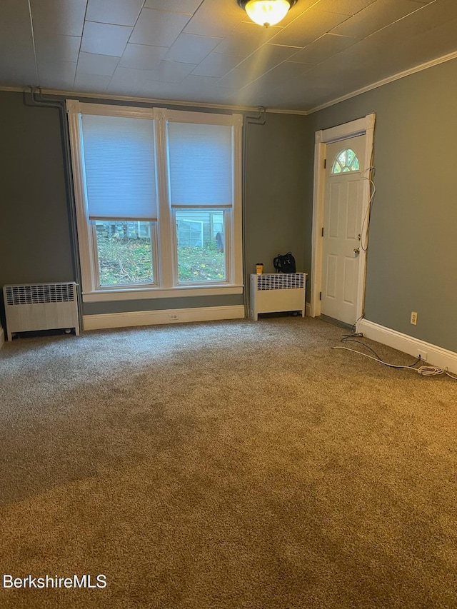 carpeted empty room featuring radiator and ornamental molding