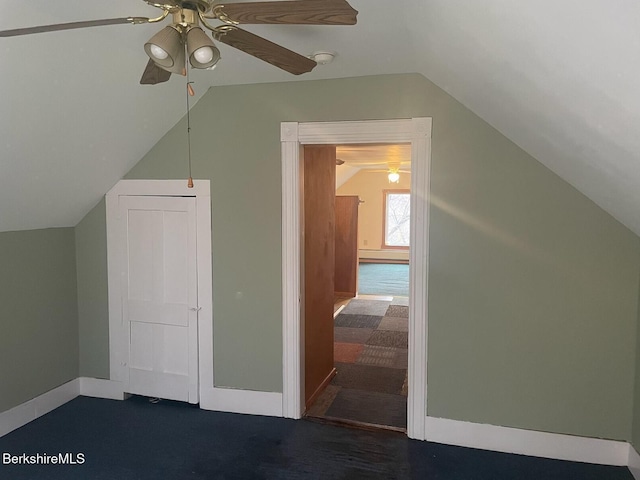 additional living space with ceiling fan, dark carpet, and vaulted ceiling