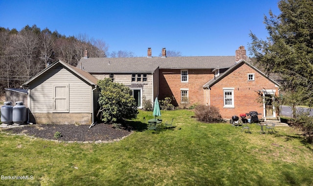 rear view of house featuring a yard