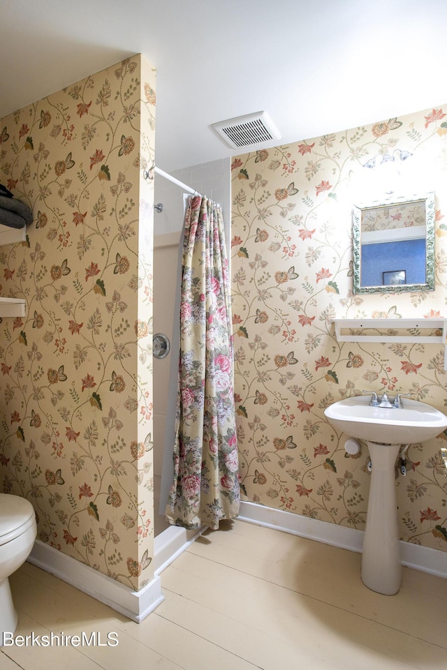 bathroom with a shower with curtain and toilet