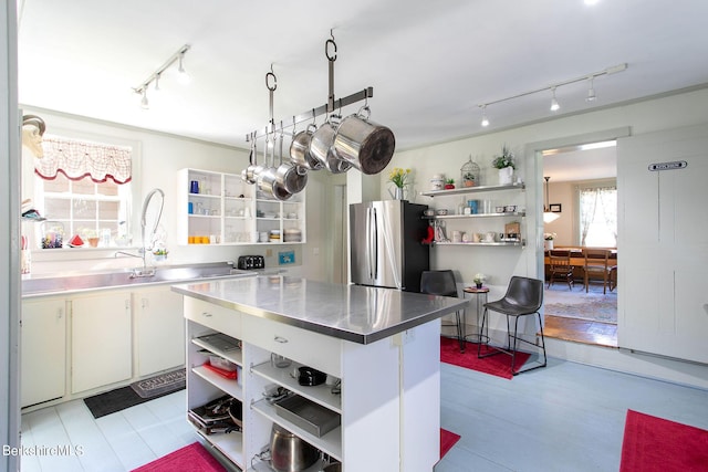 kitchen featuring white cabinets, stainless steel counters, and stainless steel refrigerator